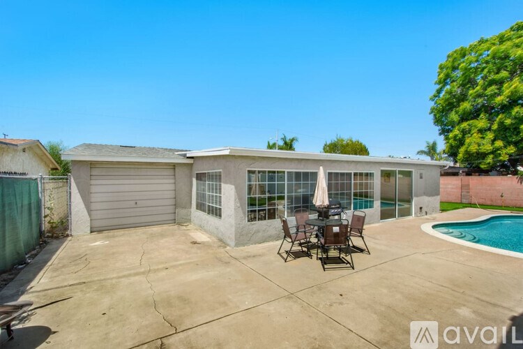 A house with a pool and patio furniture.