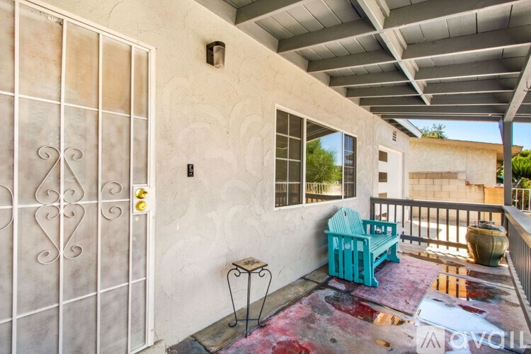 A balcony with a blue chair and a table.