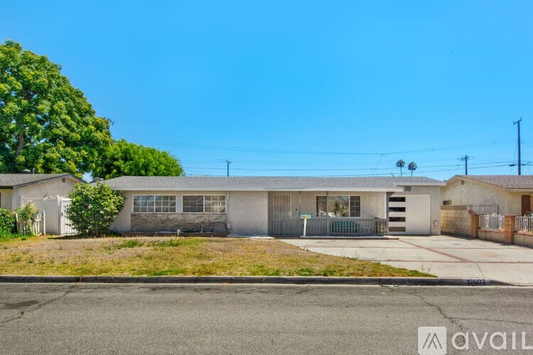 A house with a fence and a tree in front of it.