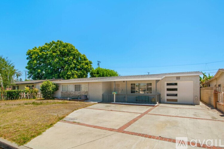 A house with a garage and a driveway in front of it.