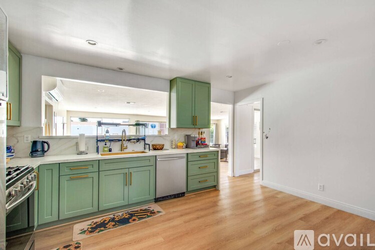 A kitchen with green cabinets and a white countertop.