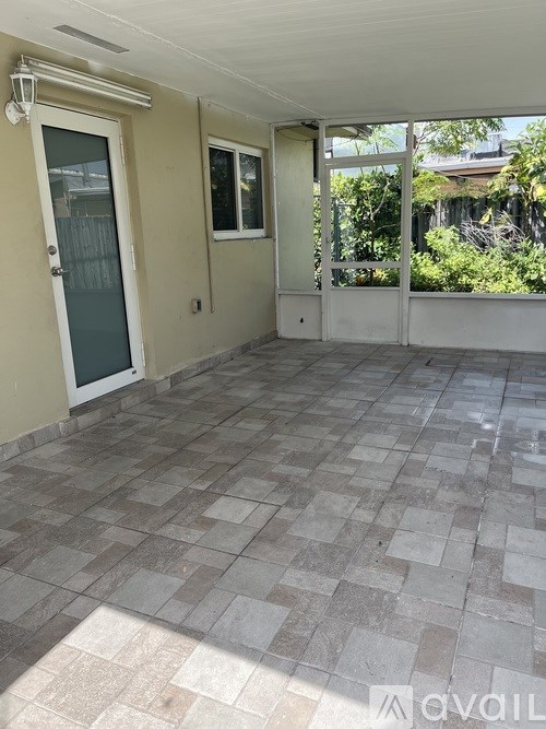 A tiled patio area with a door and a window.