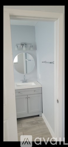 A bathroom with a sink, mirror, and cabinets.