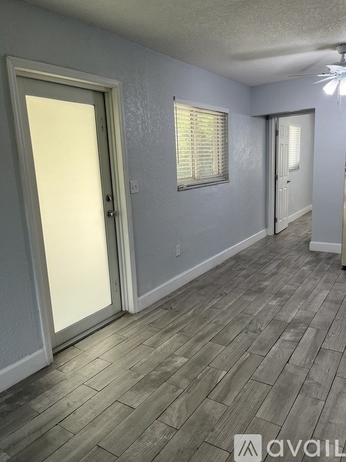 A room with a wooden floor and a sliding glass door.
