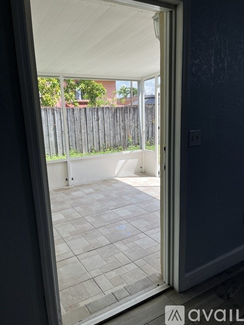 A patio with a tiled floor and a white door is visible.