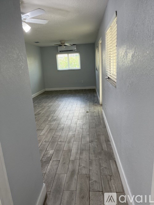 A room with wooden flooring and a window with blinds.