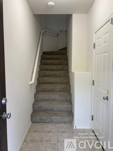 A hallway with a staircase and a door.