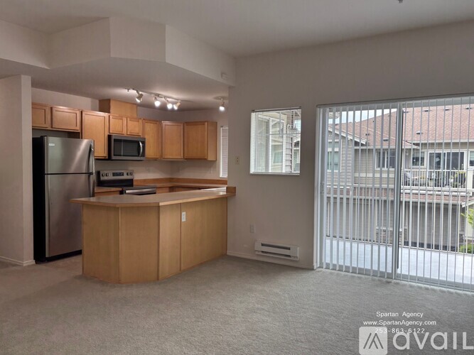 A kitchen with wooden cabinets and a stainless steel refrigerator.