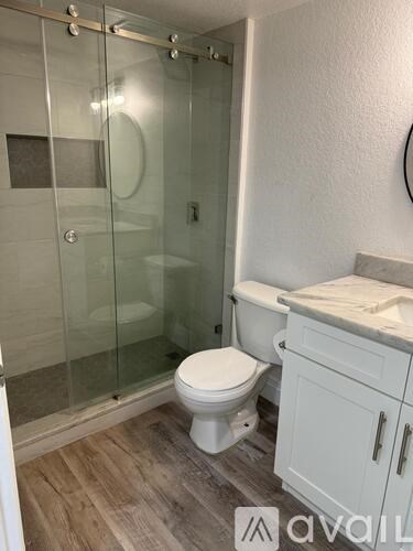 A white toilet in a bathroom with a glass shower door.