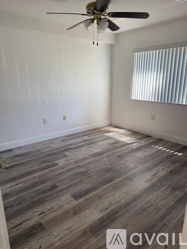 A room with wooden flooring and a ceiling fan.