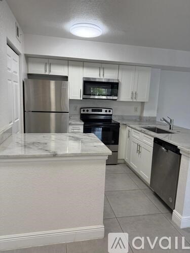 A kitchen with a stainless steel refrigerator and a stove top oven.