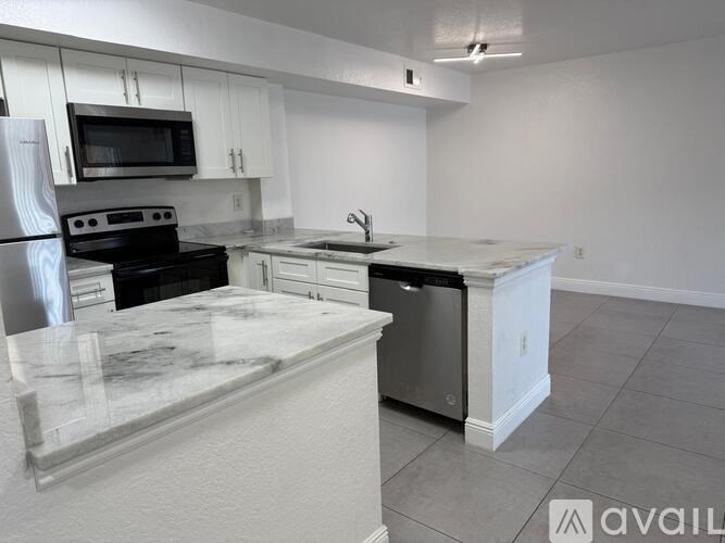 A kitchen with a white island and stainless steel appliances.