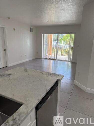 A kitchen with a marble countertop and a dishwasher.