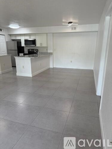 A kitchen with white cabinets and a white island in the middle.