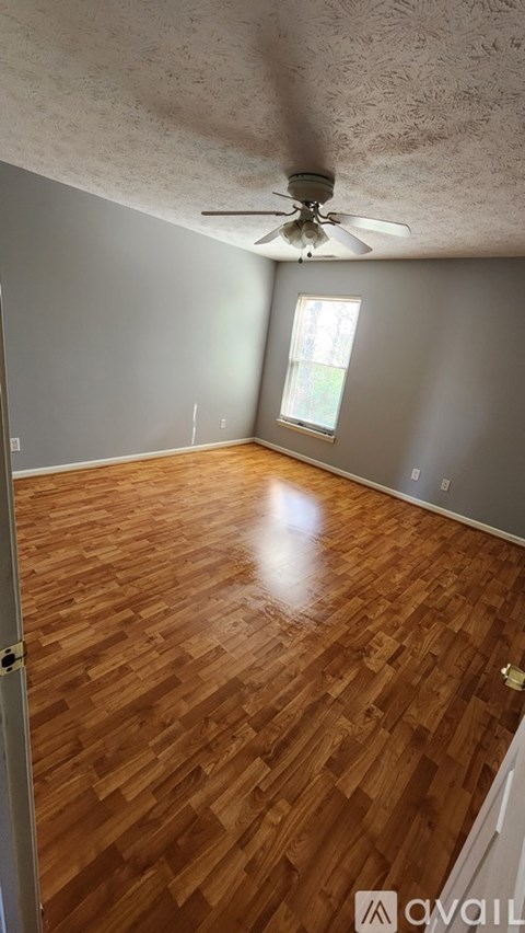A room with wooden flooring and a ceiling fan.