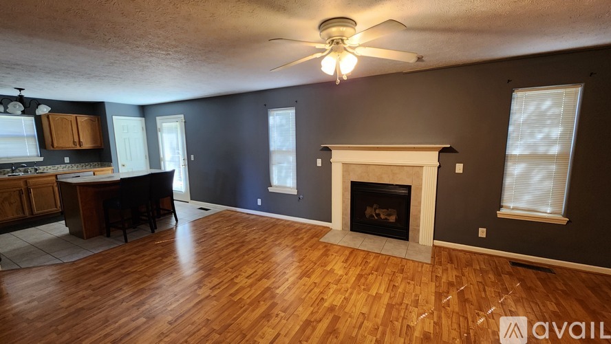 A living room with a fireplace and a ceiling fan.