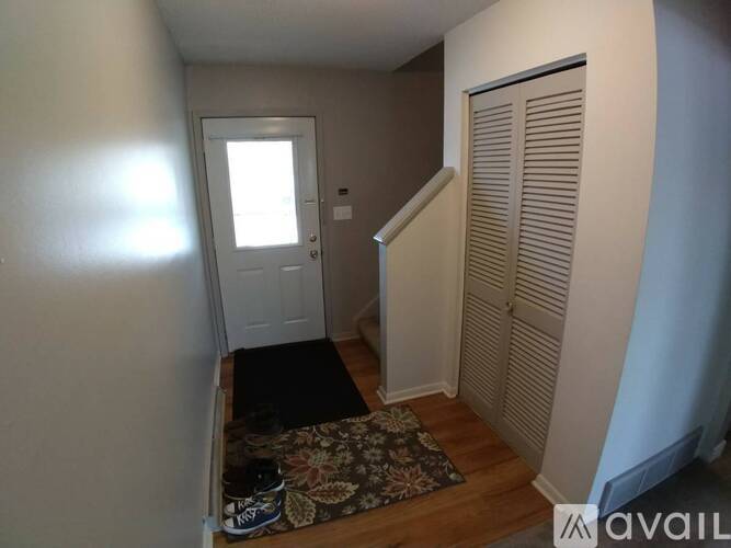 A room with a door and a rug on the floor.