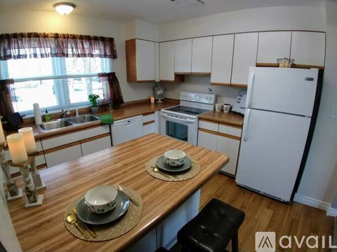 A kitchen with a wooden table and white appliances.