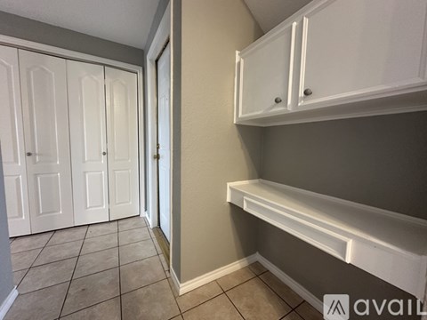 A kitchen pantry with white cabinets and a tiled floor.