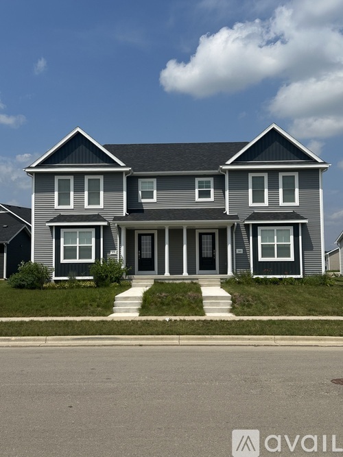 A two-story house with a grey exterior and a black roof.