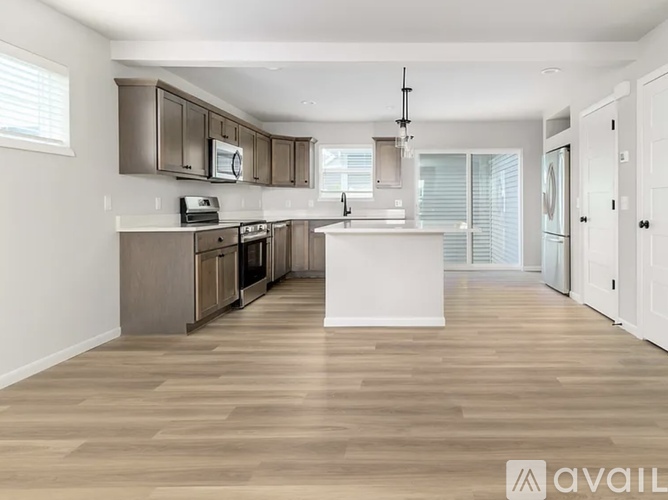 A spacious kitchen with wooden floors and modern appliances.