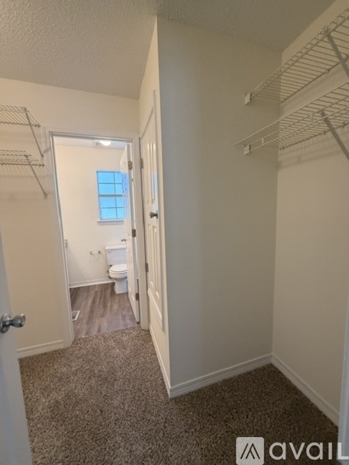A small bedroom with a toilet and a window.