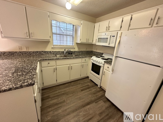 A kitchen with white appliances and cabinets.