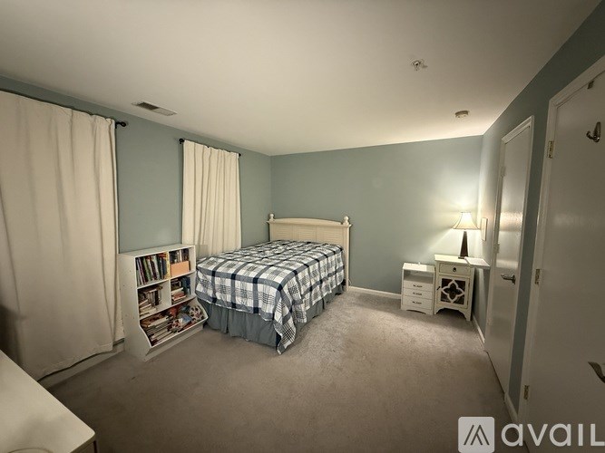 A bedroom with a bed, nightstand, and bookshelf.