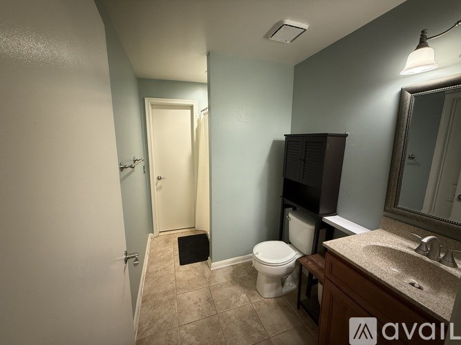 A bathroom with a toilet, sink, and mirror.