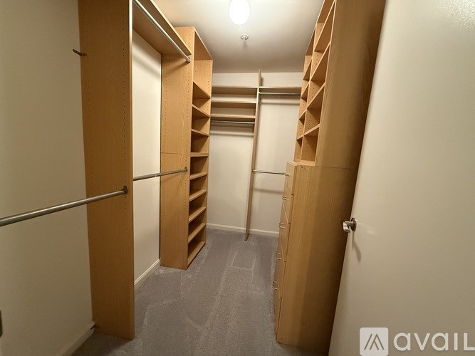 A hallway with wooden shelves on the side and a metal pole in the middle.