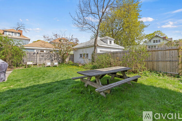 A backyard with a picnic table and a tree.