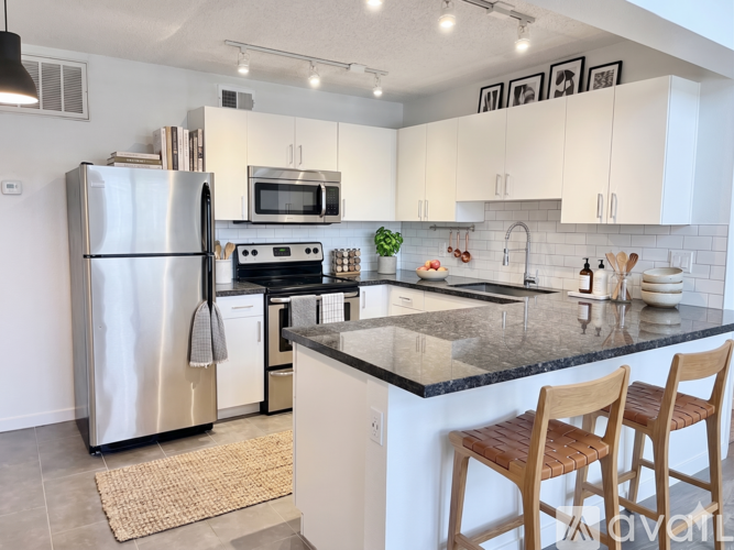 A modern kitchen with a stainless steel refrigerator, microwave, oven, and sink.