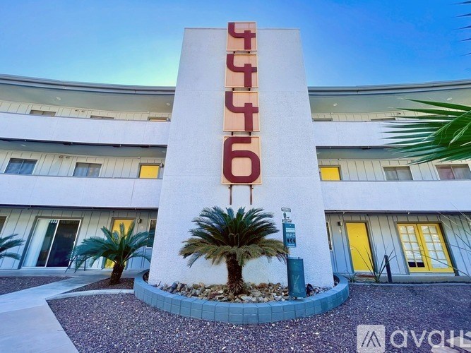 A tall white building with a red sign on it.