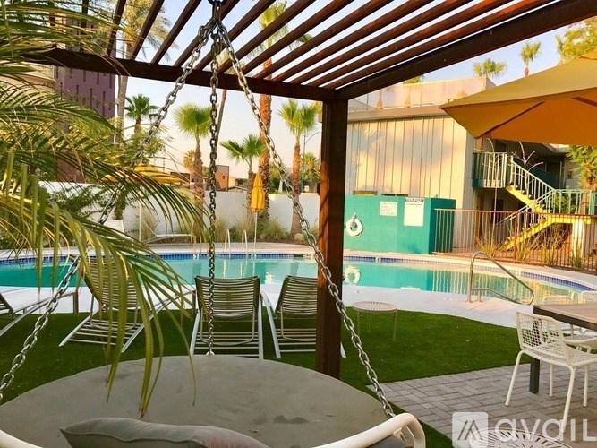 A patio with a table, chairs and a swing.