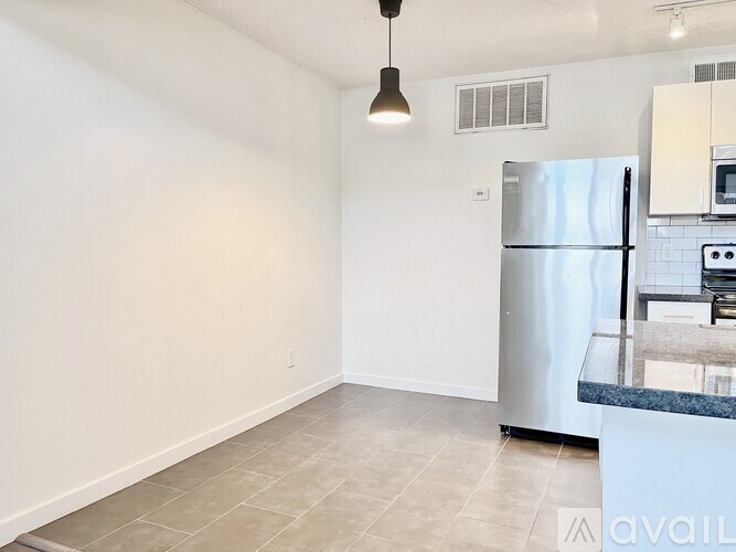 A kitchen with a refrigerator, microwave, and oven.