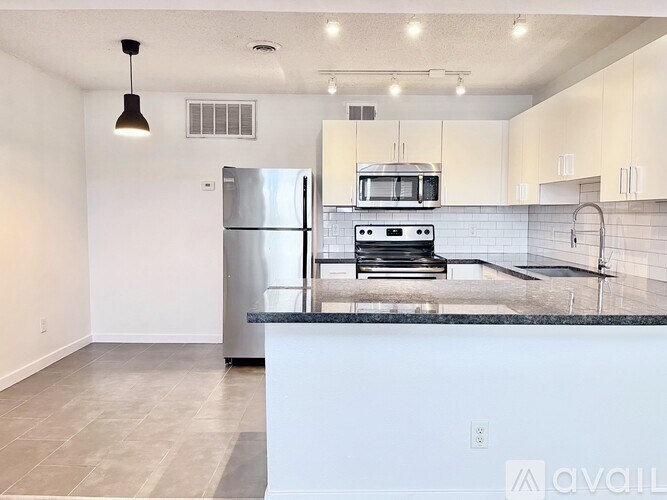 A kitchen with a refrigerator, oven, and microwave.