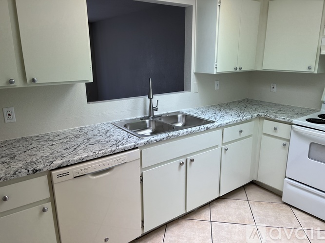 A kitchen with white appliances and a marble countertop.