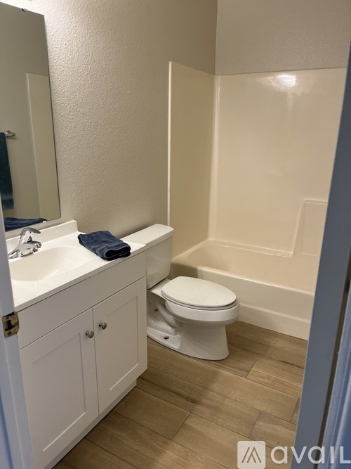 A white toilet sits in a bathroom next to a sink.