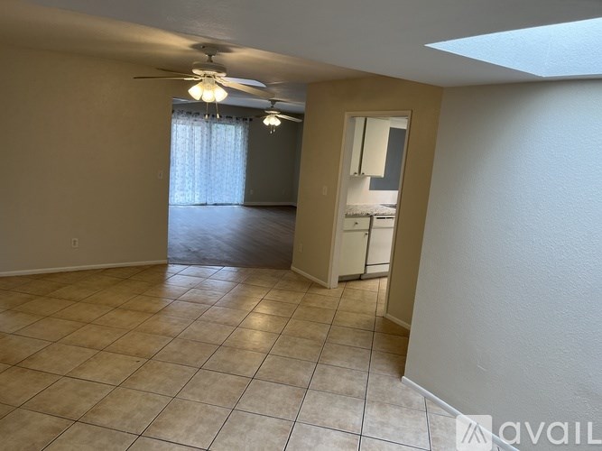 A room with a ceiling fan and tile flooring.