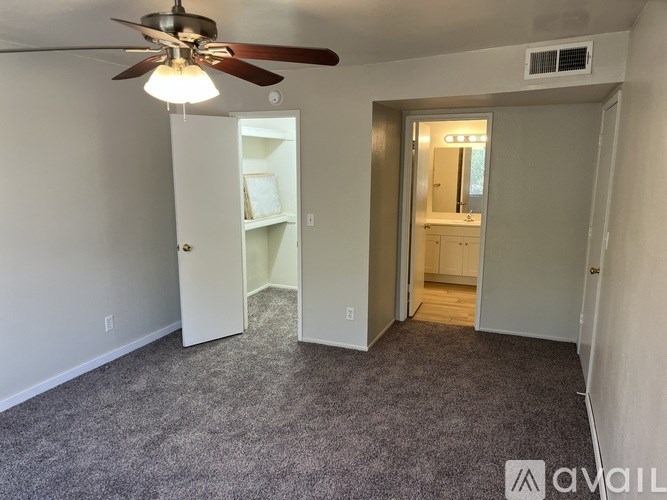 A room with a ceiling fan and a carpeted floor.