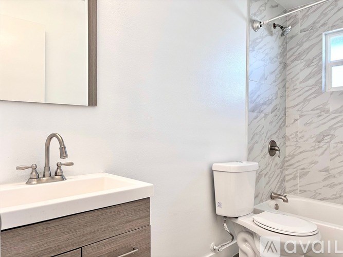 A bathroom with a sink, toilet, and a bathtub.