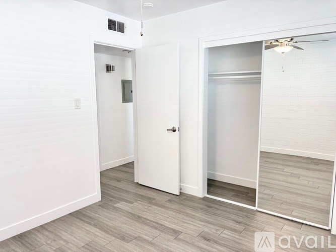 A room with a white door and a white ceiling fan.