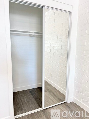 A white closet with a mirrored door is open.