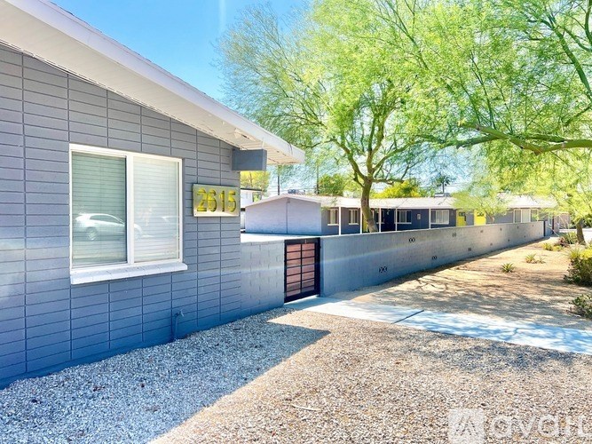 A house numbered 2615 with a gravel driveway and a tree in the background.