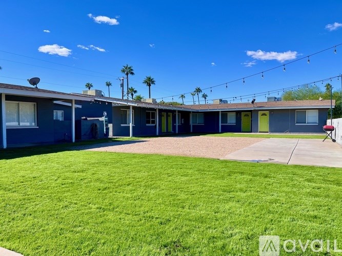 A sunny day at a row of houses with a green lawn in the foreground.