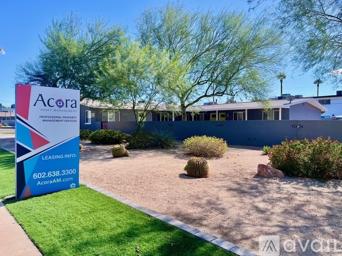 A sign for Acora Professional Property Management in front of a building.