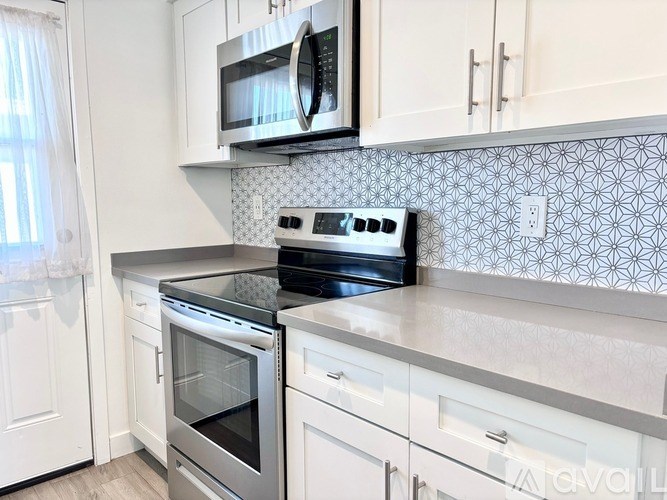 A kitchen with white cabinets and a black stove top oven.