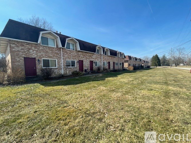 A row of houses with a grassy field in front.