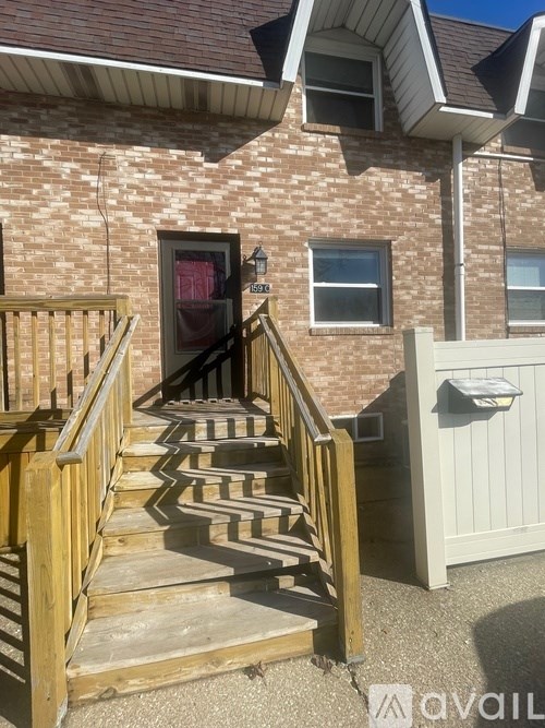 A house with a red door and a wooden staircase leading to it.