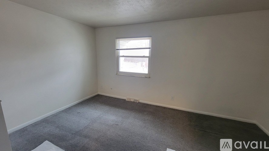 A room with a window and carpeted floor.